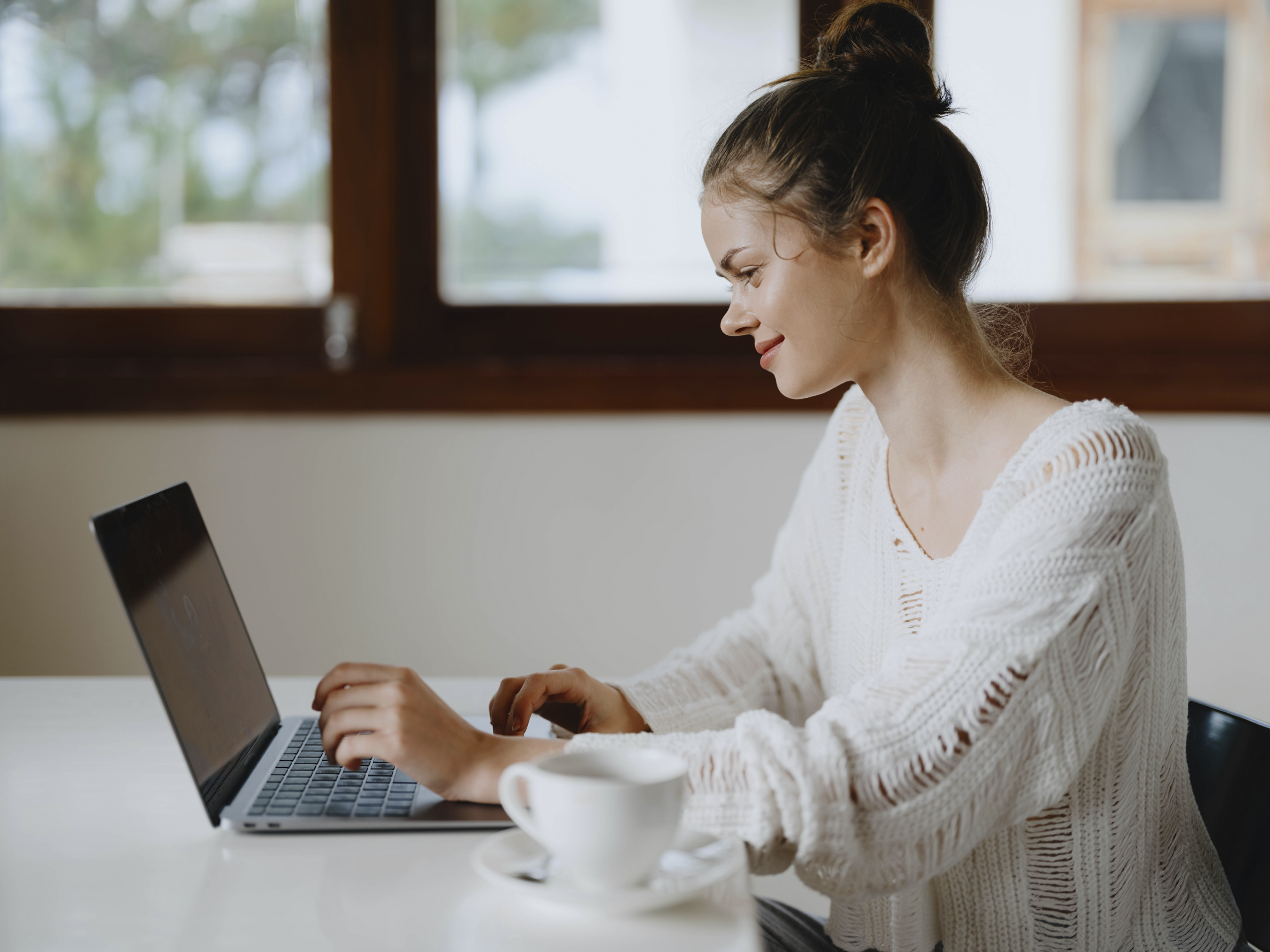 creative-young-woman-working-at-a-desk-at-home-in-a-cozy-interior-with-a-cup-of-drink-home-office-freelancer-with-a-smile-communication-and-education-online
