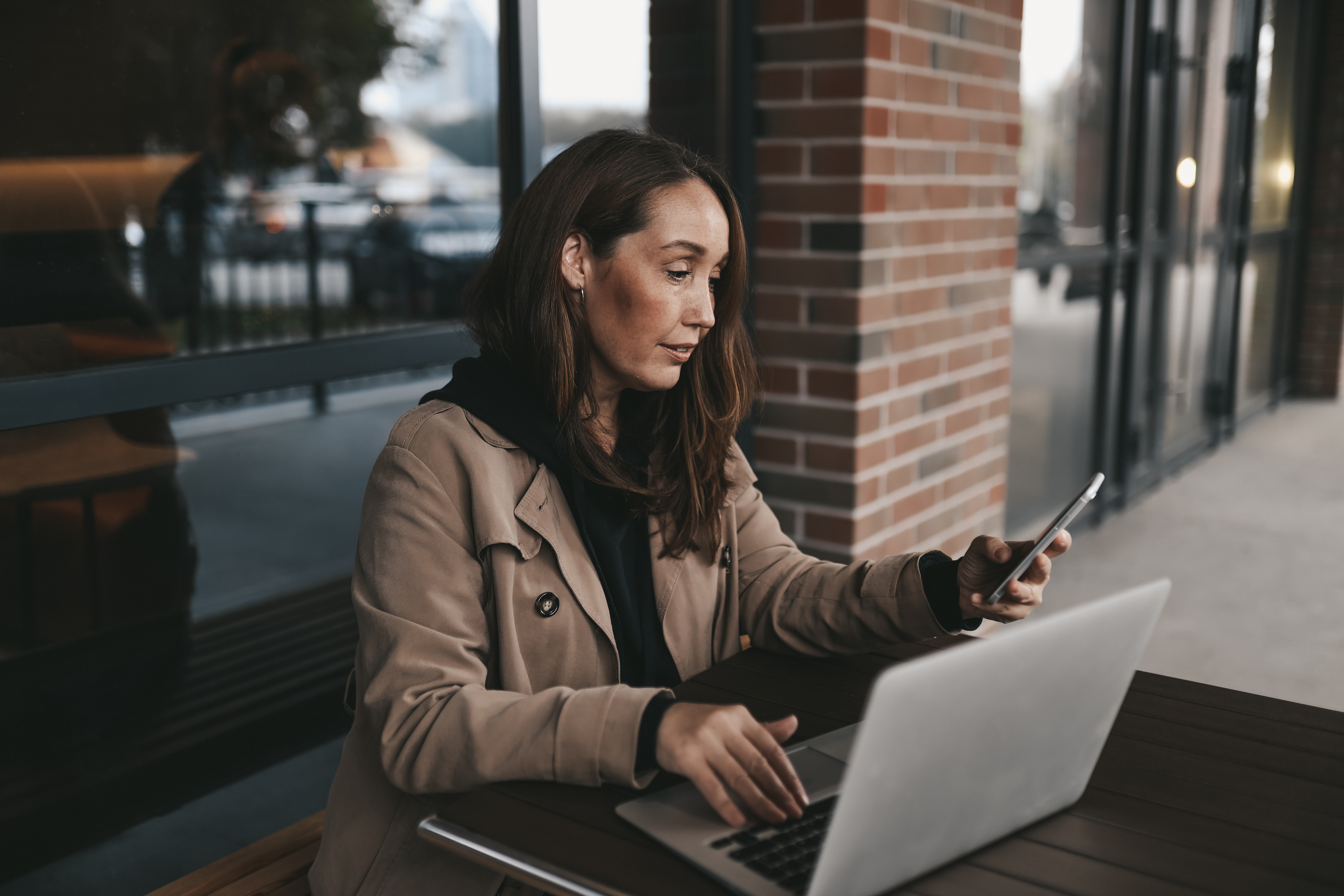 adult-business-woman-freelancer-works-using-wireless-technology-talking-phone-sitting-cafe