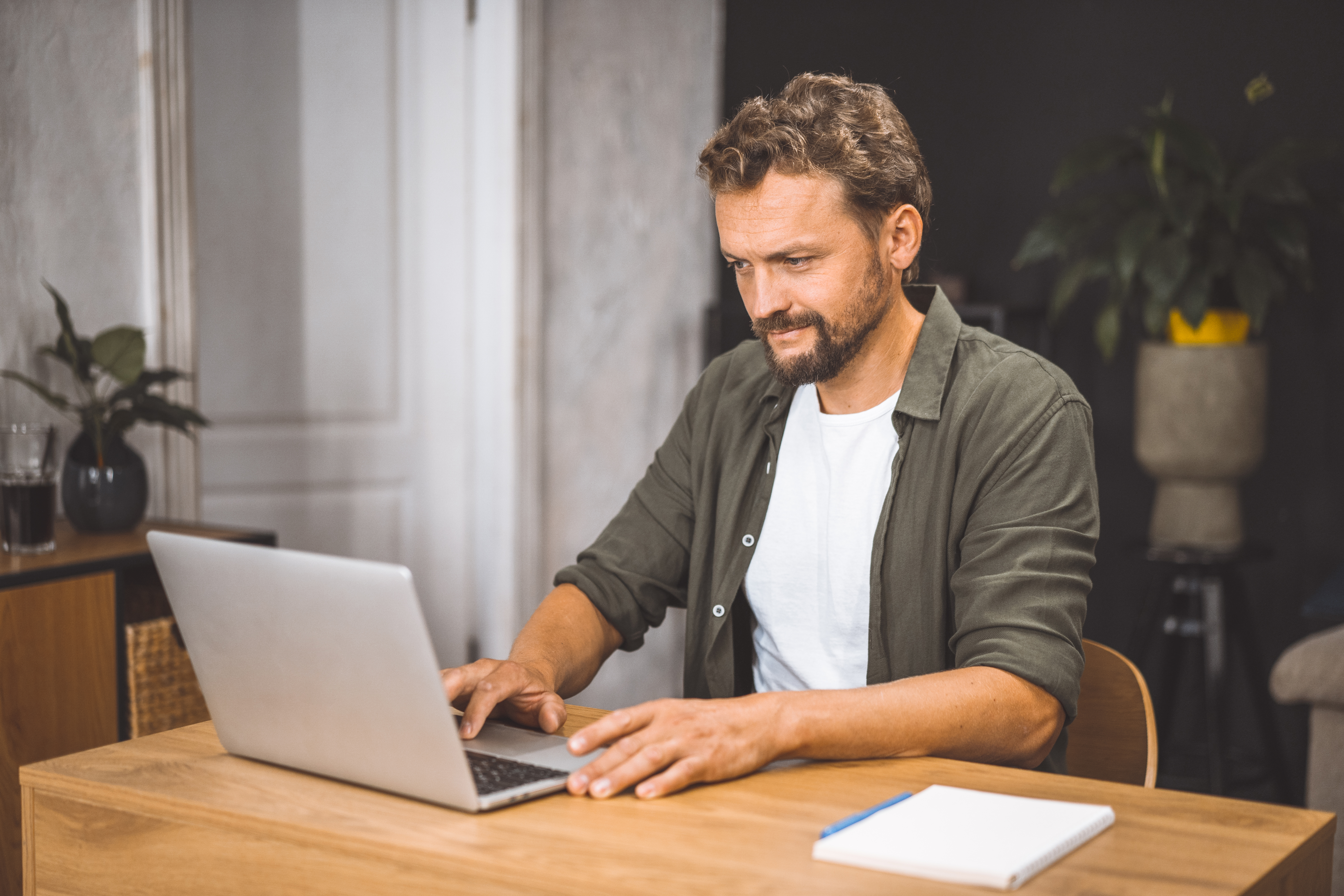 modern-freelancer-lifestyle-man-intently-focused-on-laptop-sitting-in-cozy-home-office-concept-of-working-from-home-emphasizing-the-freedom-and-flexibility-that-comes-with-being-self-employed
