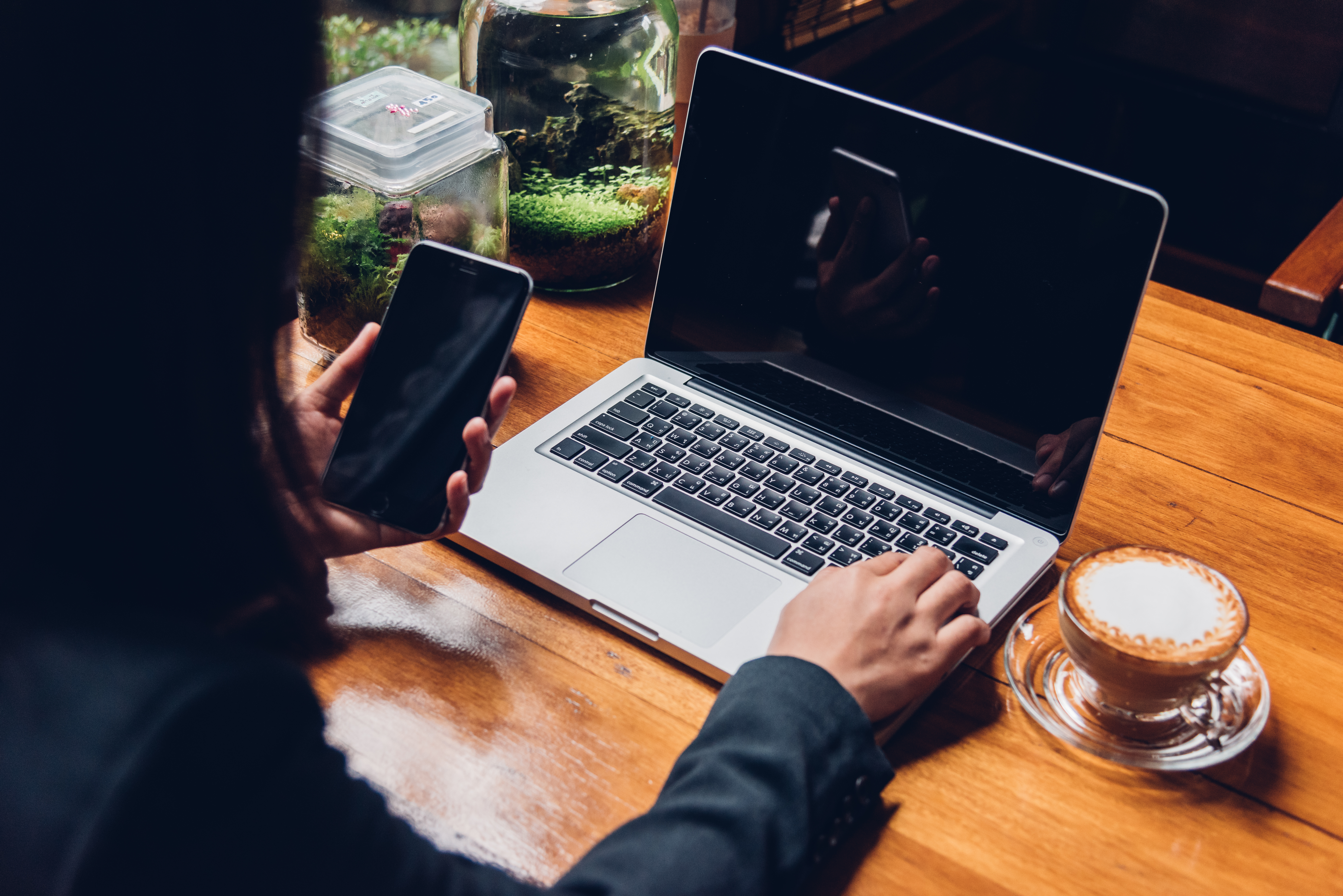 beautiful-young-businesswoman-using-smart-phone-on-the-computer