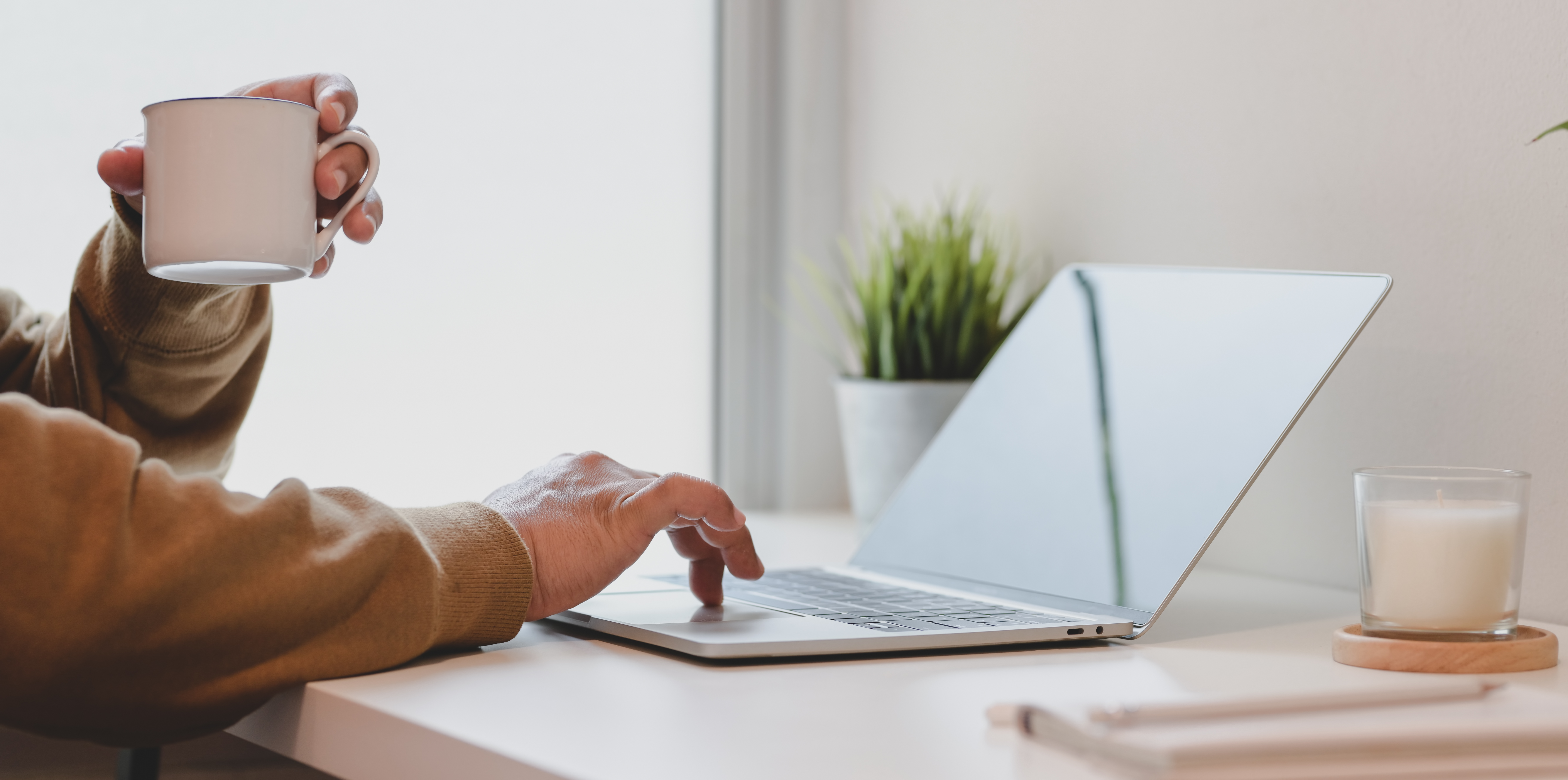 woman-typing-on-laptop-while-drinking-a-cup-of-coffee