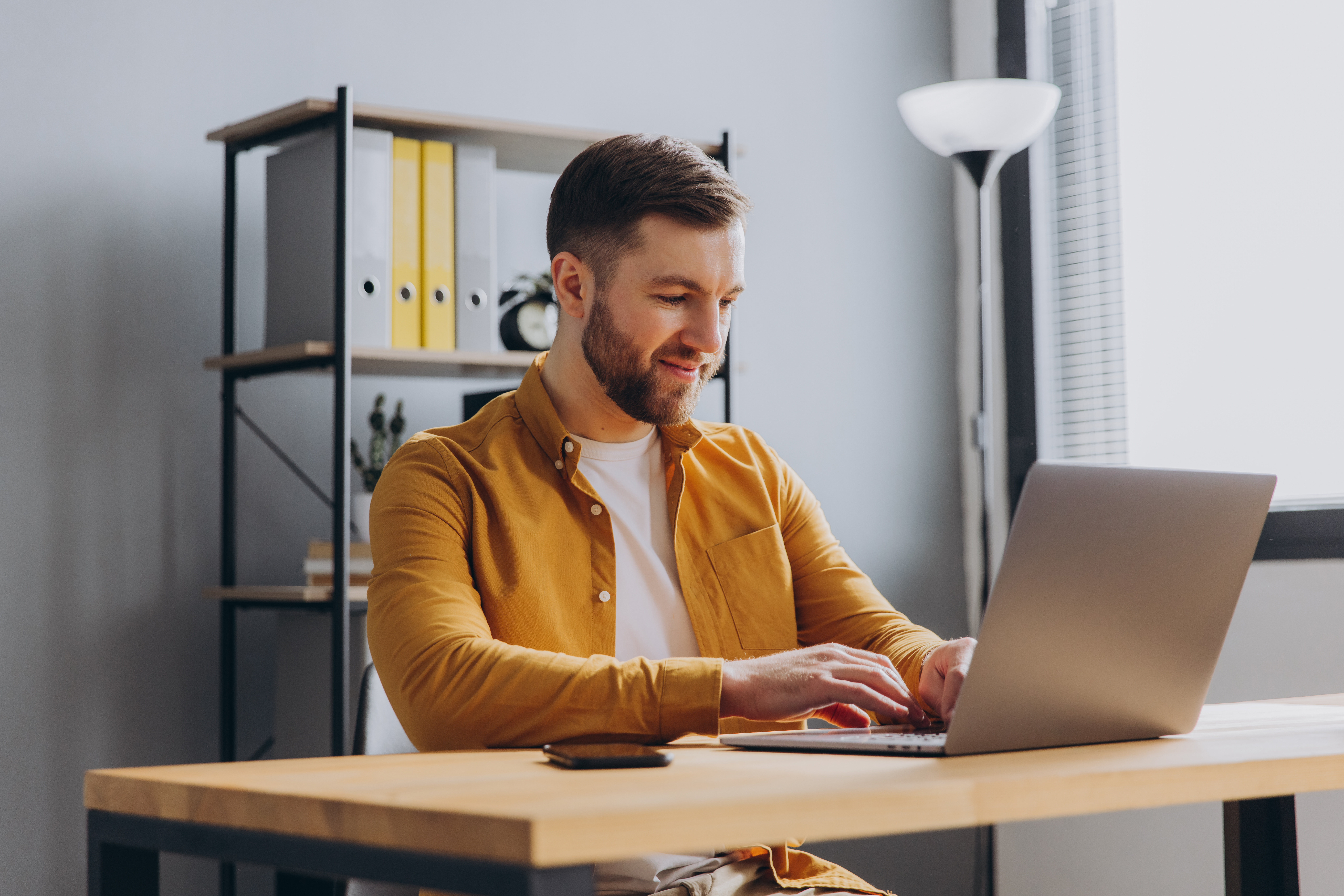 portrait-of-a-modern-businessman-man-in-a-yellow-shirt-working-o