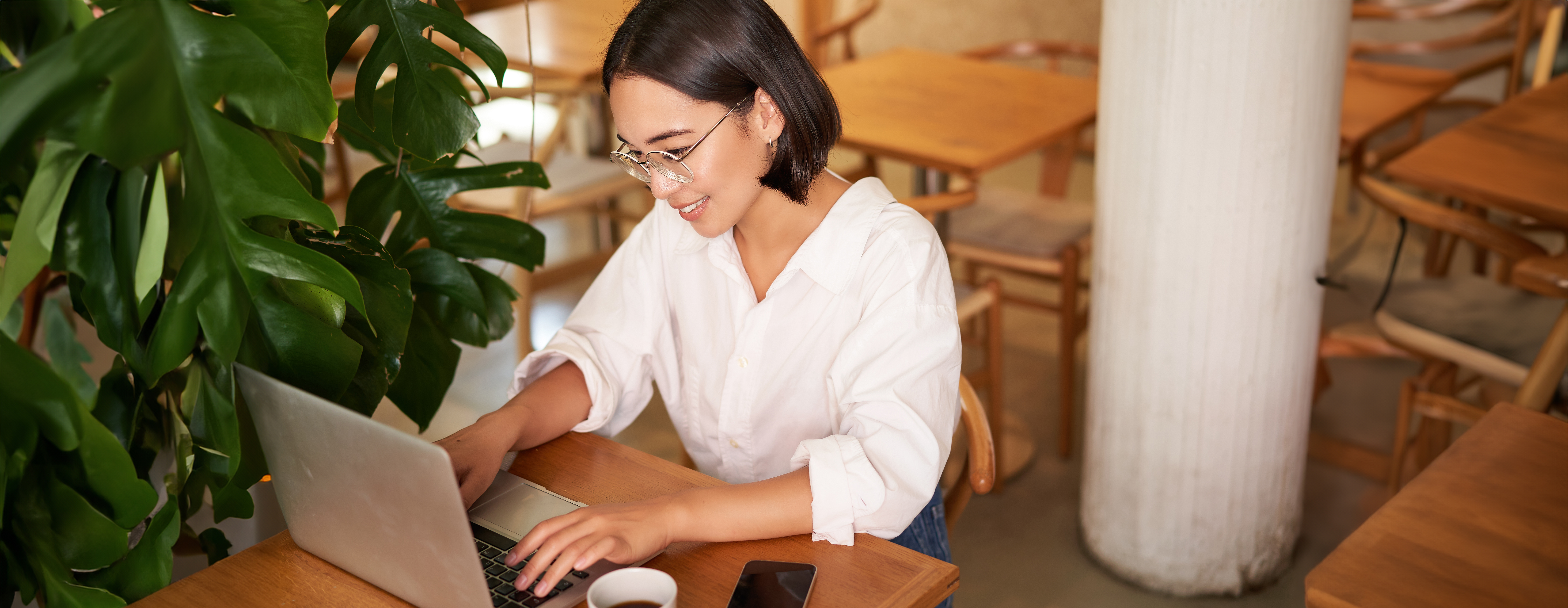 working-female-entrepreneur-sitting-in-cafe-with-laptop-typing-on-computer-drinking-coffee