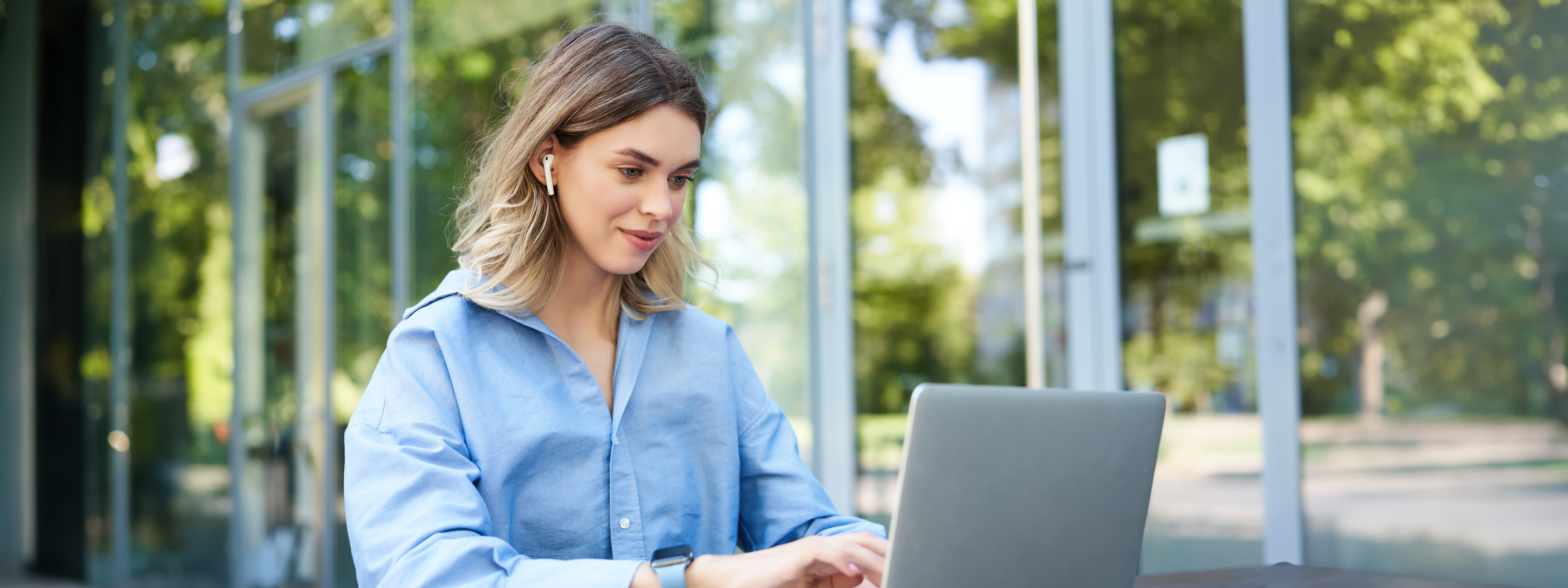 portrait-of-corporate-woman-working-outside-office-on-remote-sitting-with-laptop-wireless-earphones-attend-online-video-conference
