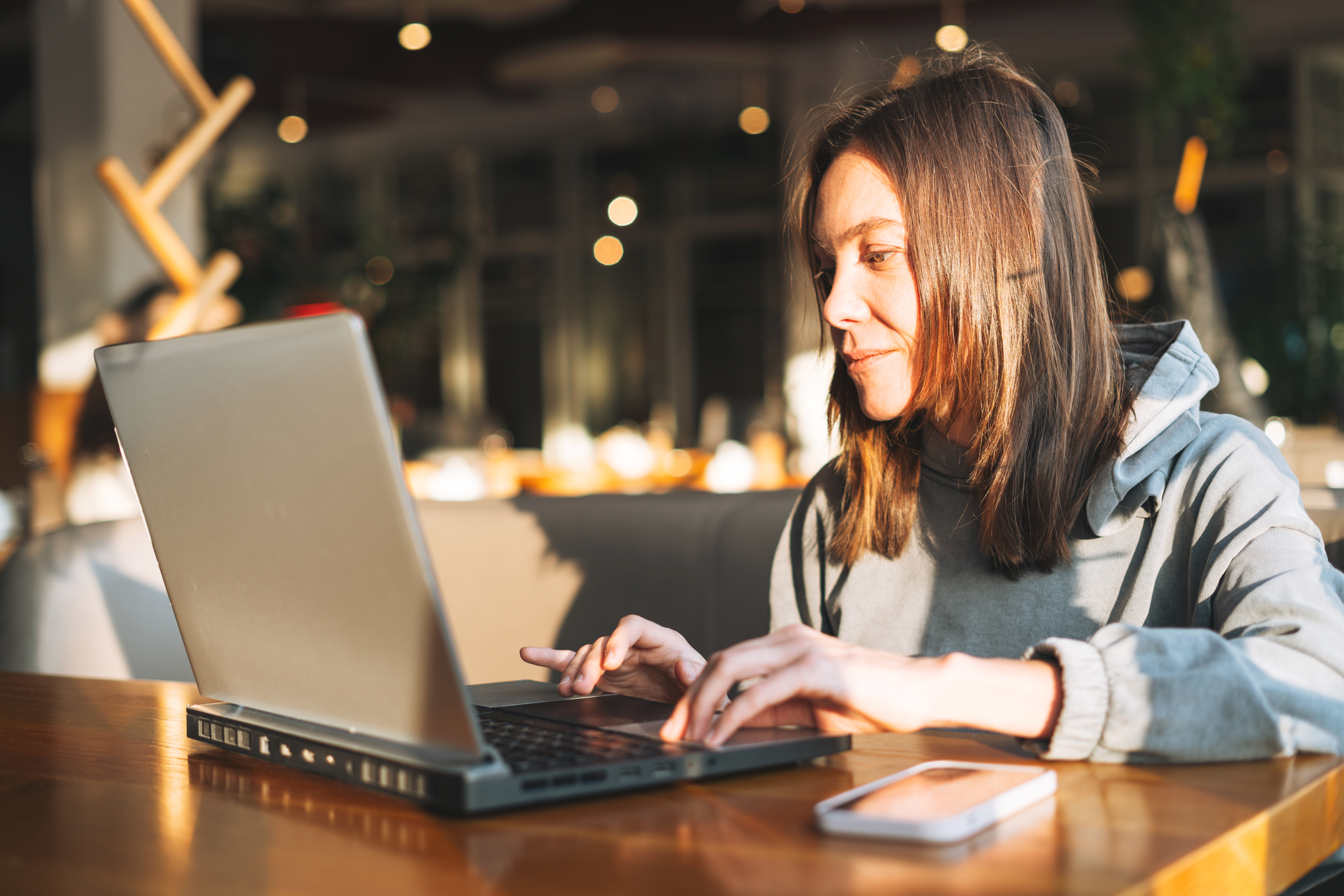 young-brunette-woman-in-casual-clothes-working-with-laptop-using
