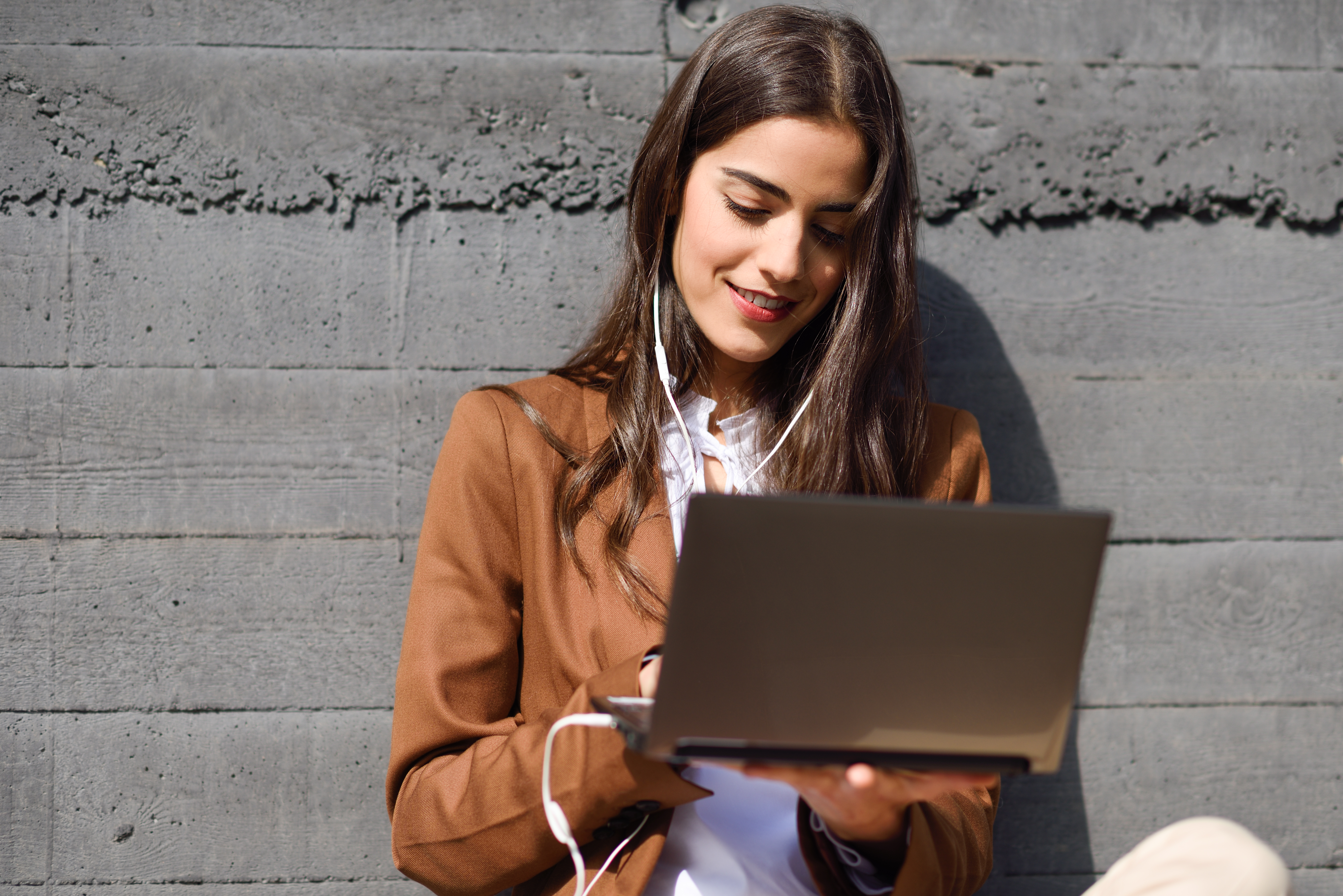 young-businesswoman-sitting-on-floor-looking-at-her-laptop-compu